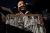 John Minchillo - AP
A demonstrator carries a sign bearing images of former Minneapolis police officer Derek Chauvin and others during a protest on April 15, 2021, in Brooklyn Center, Minn. Closing arguments in Chauvin's trial in the death of George Floyd are scheduled to begin Monday.