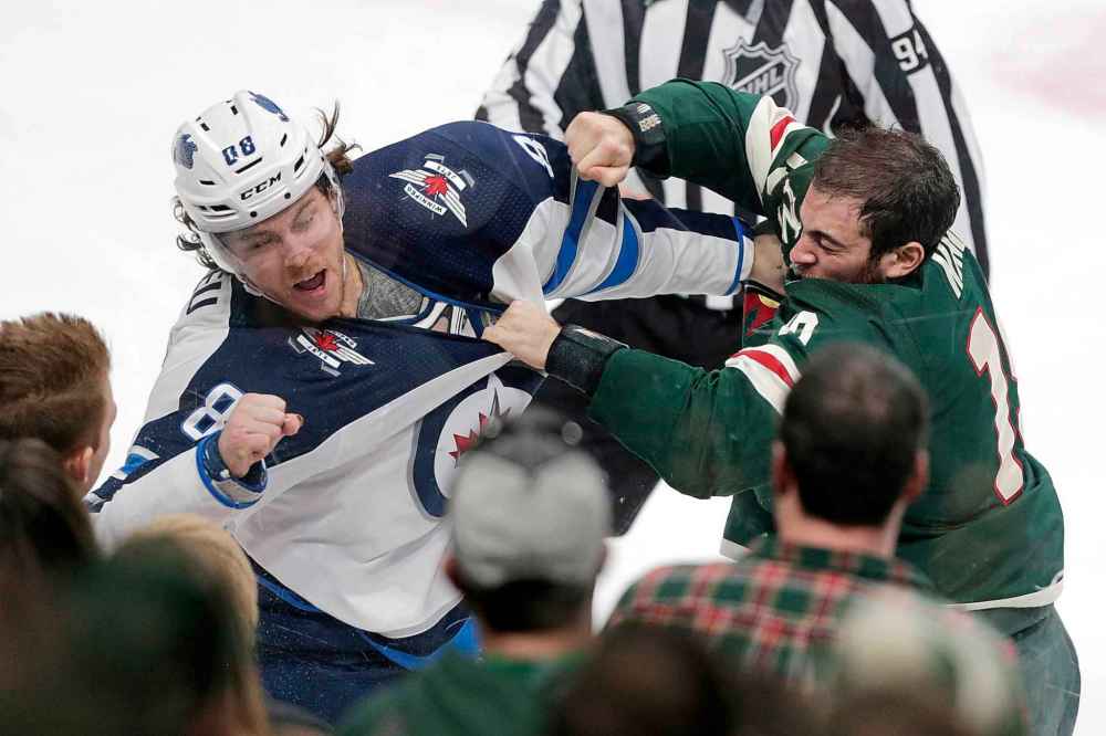 Winnipeg Jets defenseman Nathan Beaulieu (88) and Minnesota Wild center Luke Kunin (19) fight in the third period. (Andy Clayton-King / The Associated Press)