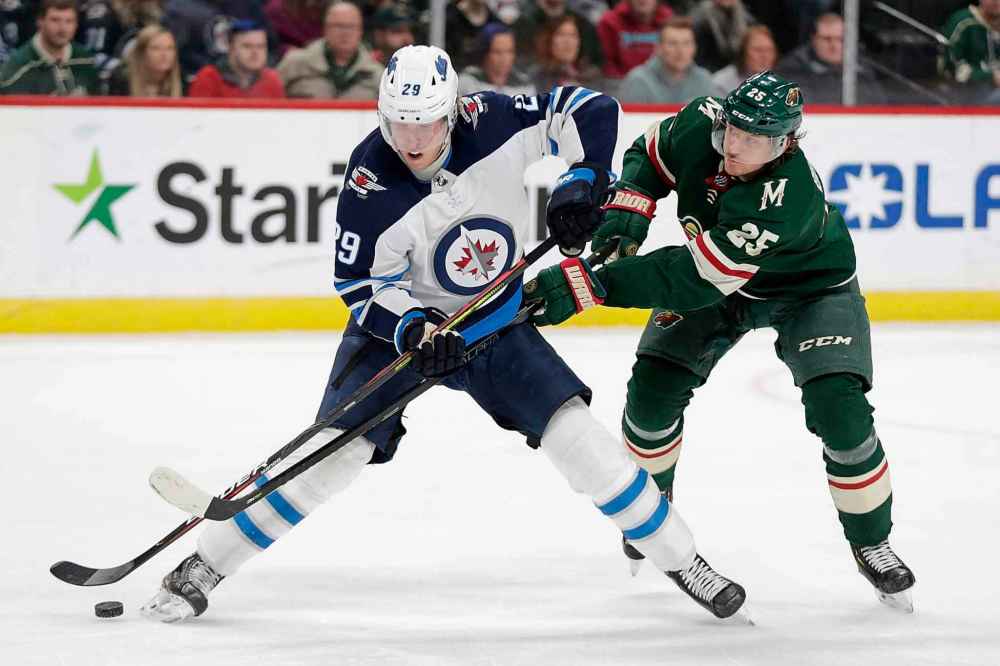 Winnipeg Jets center Partrik Laine (29) and Minnesota Wild defenseman Jonas Brodin (25) battle for the puck in the second period. (Andy Clayton-King / The Associated Press)