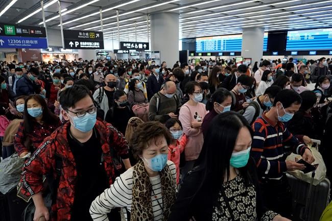 Passengers wear protective face masks at the departure hall of the high speed train station in Hong Kong, Thursday, Jan. 23, 2020. China closed off a city of more than 11 million people Thursday, halting transportation and warning against public gatherings, to try to stop the spread of a deadly new virus that has sickened hundreds and spread to other cities and countries in the Lunar New Year travel rush. (AP Photo/Kin Cheung)