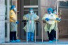 Security guards and a heath-care worker wait for patients at the Women’s College Hospital Covid-19 testing centre on Saturday June 6, 2020. THE CANADIAN PRESS/Frank Gunn