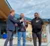 Marc Miller, federal Indigenous services minister, from left, Herb Redsky Jr. and Shoal Lake 40 Chief Vernon Redsky, stand in front of the Harvey Redsky Memorial School and toast safe tap water. Melissa Martin / Winnipeg Free Press