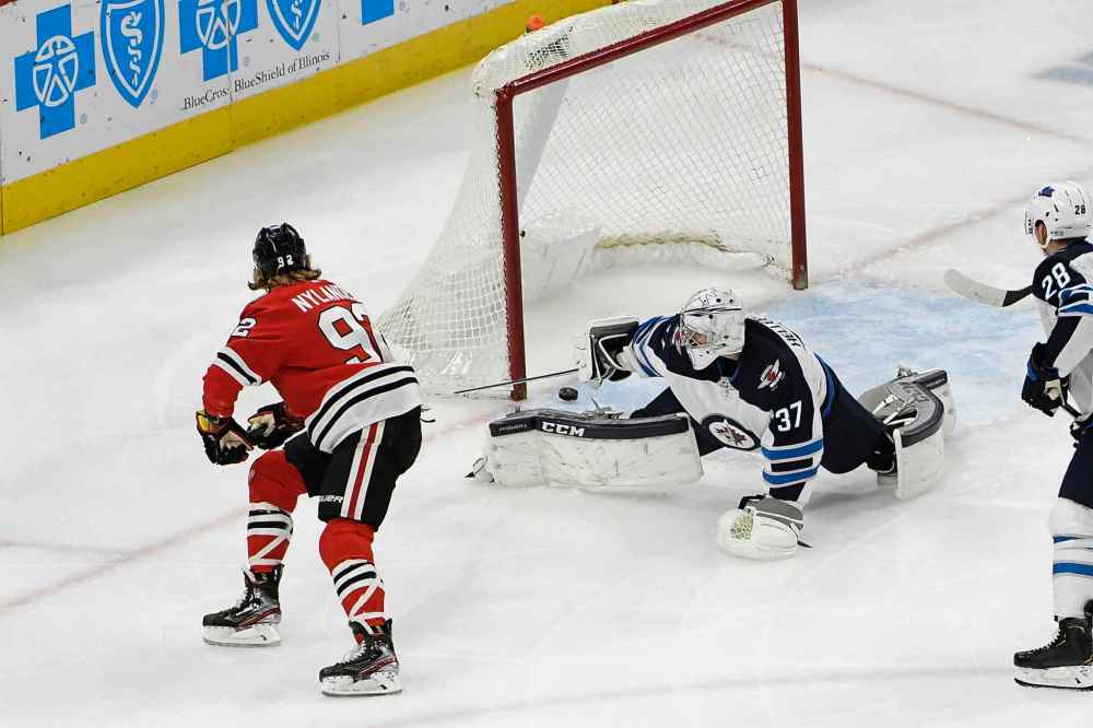 Chicago Blackhawks left wing Alex Nylander (92) scores a goal against Winnipeg Jets goaltender Connor Hellebuyck (37) during the first period. (David Banks / The Associated Press)