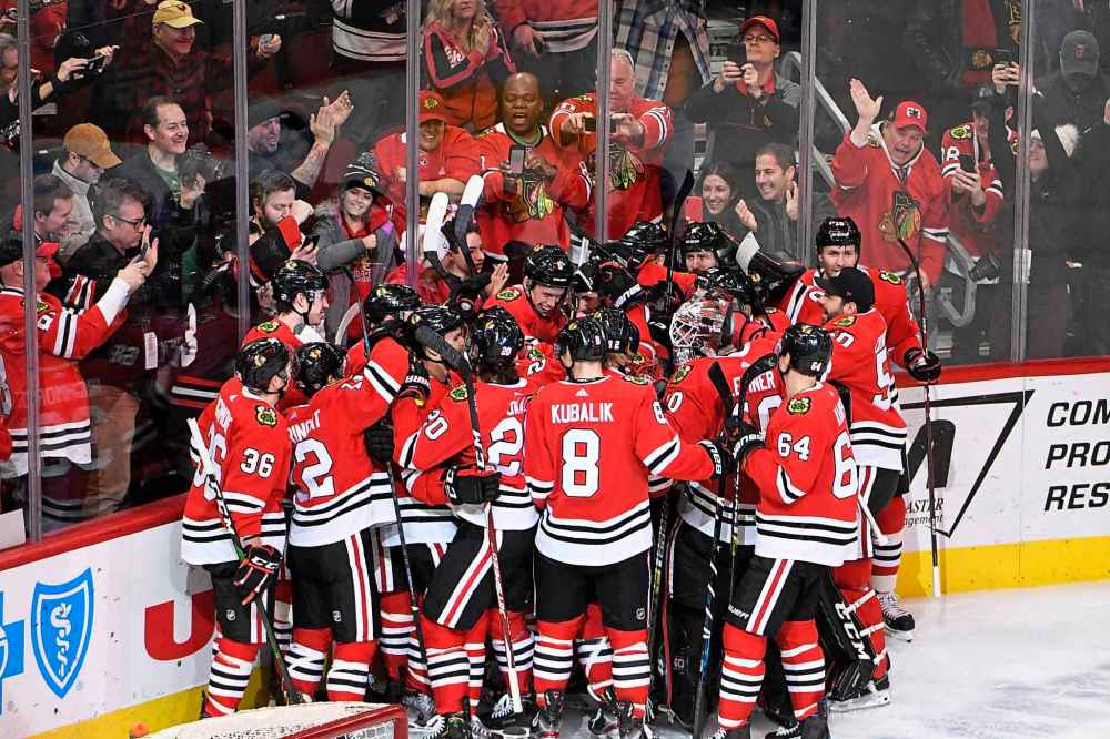 The Chicago Blackhawks celebrate Chicago Blackhawks right wing Patrick Kane (88) 1,000th point on an assist against the Winnipeg Jets during the third period of an NHL hockey game Sunday, Jan. 19, 2020, in Chicago. (David Banks / The Associated Press)