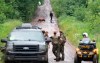 A K9 unit and police officers searches a back road on Saturday, July 11, 2020 in Saint-Apollinaire, Quebec. Quebec provincial police say two girls who were the subject of an Amber Alert have been found dead. THE CANADIAN PRESS/Jacques Boissinot