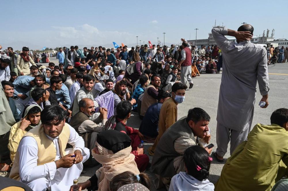 AFP Contributor#AFP - AFP via GETTY IMAGES
People wait to leave the Kabul airport on Monday after a stunningly swift end to Afghanistan's 20-year war, with thousands trying to flee the Taliban.