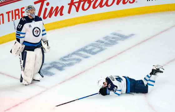 CPWinnipeg Jets' Josh Morrissey lays on the ice as Winnipeg Jets goaltender Connor Hellebuyck looks up at the replay following a short-handed goal by Montreal Canadiens' Joel Armia, not shown, during second period NHL Stanley Cup playoff hockey action in Montreal, Sunday, June 6, 2021. (Paul Chiasson / The Canadian Press)