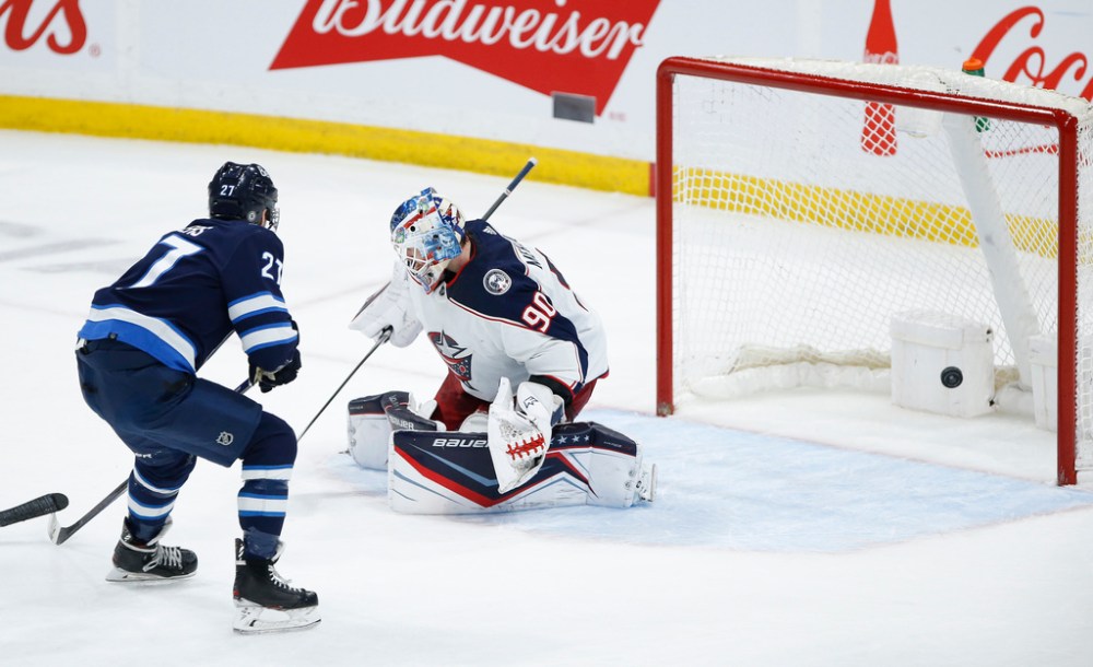 CP
Nikolaj Ehlers scores the game-winning overtime goal on Elvis Merzlikins Friday. (John Woods / The Canadian Press)