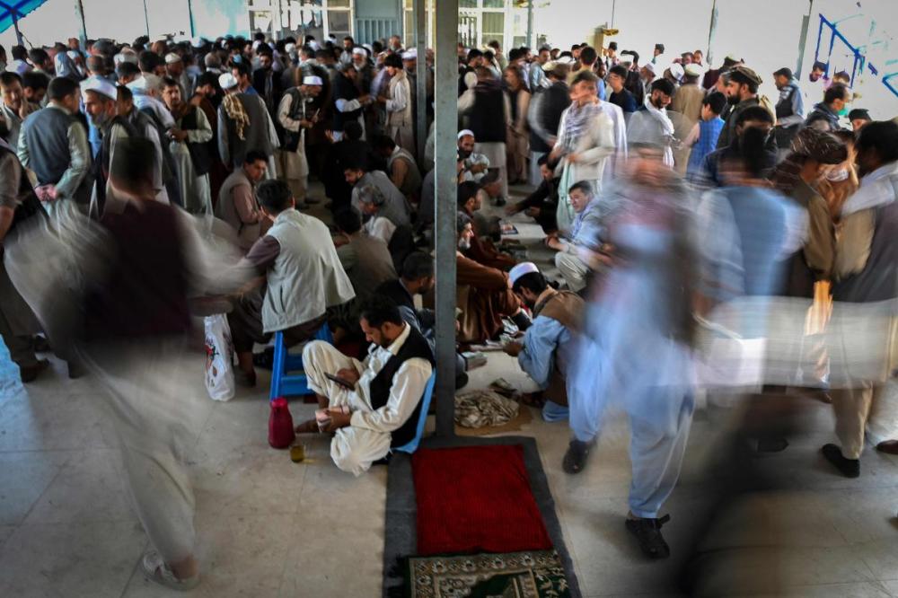 AAMIR QURESHI - AFP via GETTY IMAGES
Afghan currency exchange dealers carry out their tasks after money exchange market reopens for business in Kabul on Sunday.