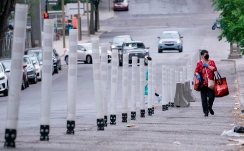 A woman walks along a sanitary corridor in Montreal, on Thursday, May 28, 2020. THE CANADIAN PRESS/Paul Chiasson
