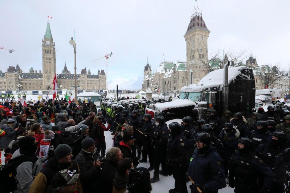 Steve Russell - Toronto Star
Police form a line as they clear protesters from the area surrounding Parliament Hill in Ottawa on Feb. 19, 2022. The Ontario Superior Court ordered several financial institutions, fundraising platforms and digital asset platforms to halt all financial transactions from the bank accounts and digital wallets belonging to protest organizers.