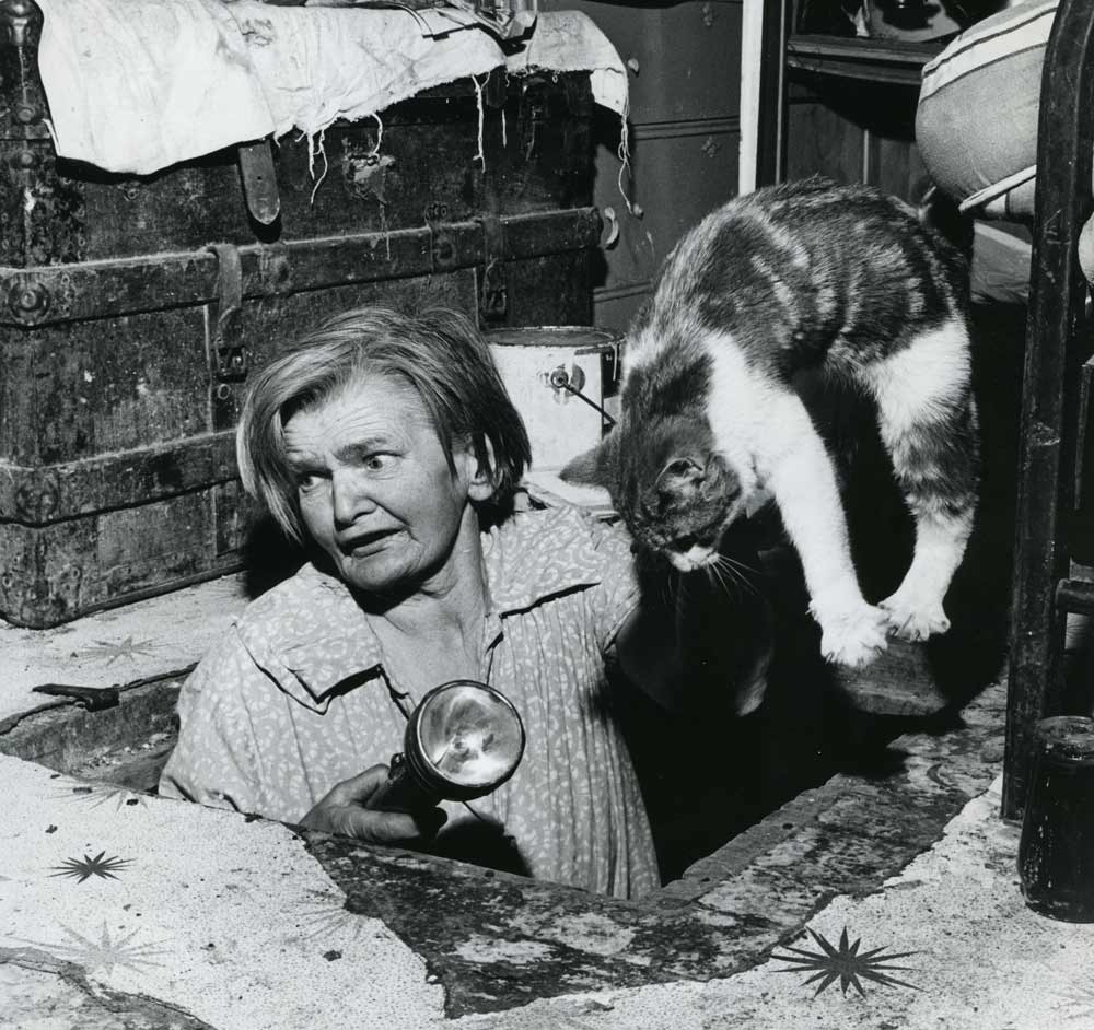 Bertha Rand lifts a cat after it got into the cellar in 1966. "That darn cat!" (Winnipeg Tribune archives)