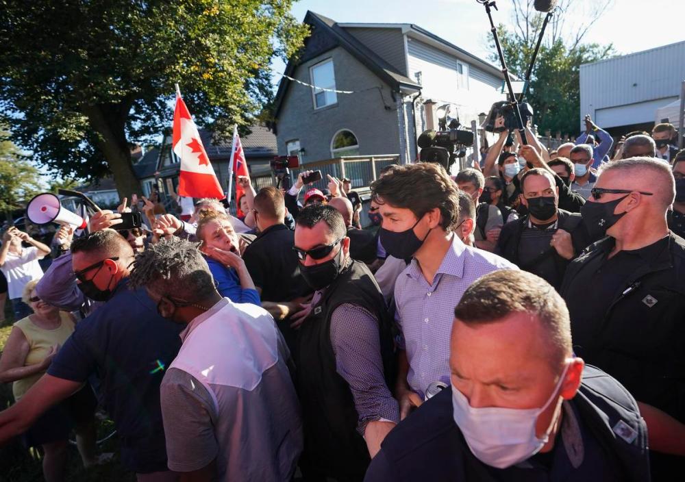 Nathan Denette - THE CANADIAN PRESS
Liberal Leader Justin Trudeau is escorted by his RCMP security detail as protesters shout and throw rocks while leaving a campaign stop at a local microbrewery Monday in London, Ont.