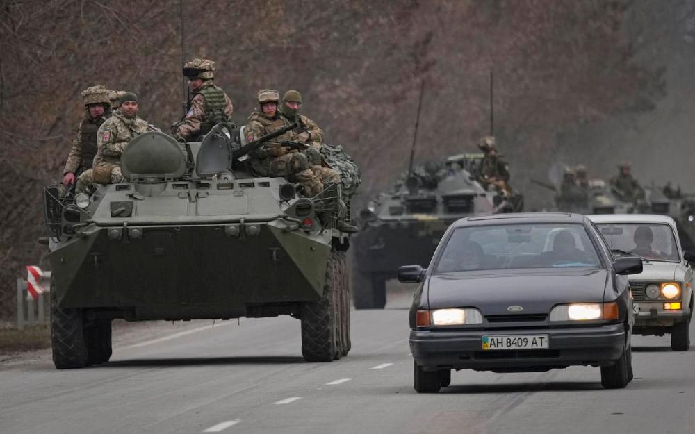 Vadim Ghirda - AP
Ukrainian servicemen sit atop armoured personnel carriers driving on a road in the Donetsk region, eastern Ukraine on Thursday, Feb. 24, 2022 after Russia’s invasion began earlier in the day.