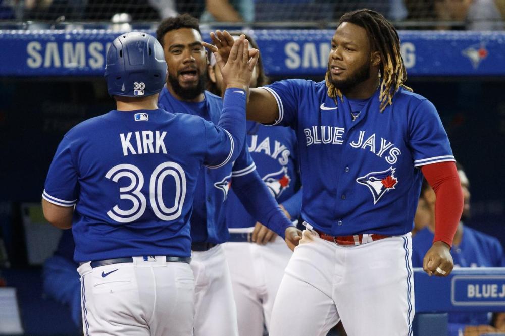 Cole Burston - GETTY IMAGES
Alejandro Kirk is welcomed to the dugout by Vladimir Guerrero Jr. after scoring in the fourth inning. Guerrero later hit his 45th home run, one more than his Hall of Fame father had in his best season.