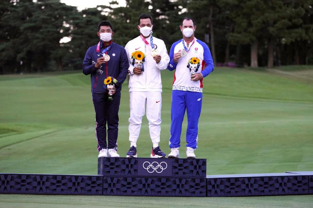 Andy Wong - AP
Xander Schauffele, of the United States, poses with his gold medal next to bronze winner C.T. Pan of Chinese Taipei, left, and silver winner Rory Sabbatini of Slovakia after the medal presentation for men’s golf at the Tokyo Olympics on Sunday.