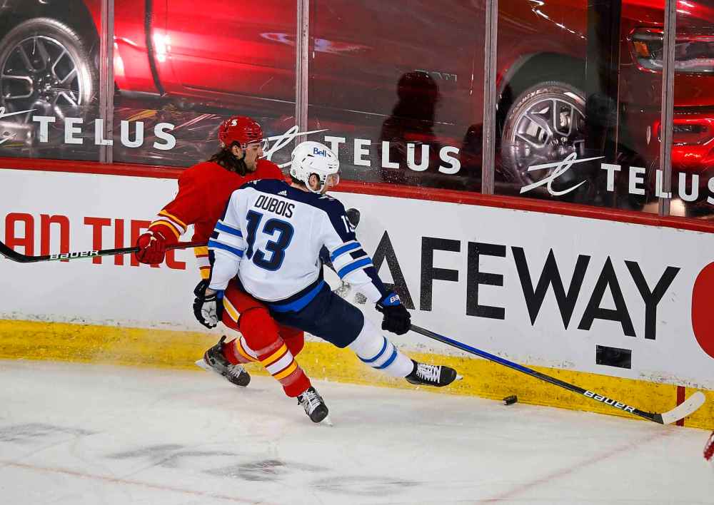 CP
Winnipeg Jets' Pierre-Luc Dubois is knocked away from the puck by Calgary Flames' Chris Tanev during the first period. (Todd Korol / The Canadian Press)