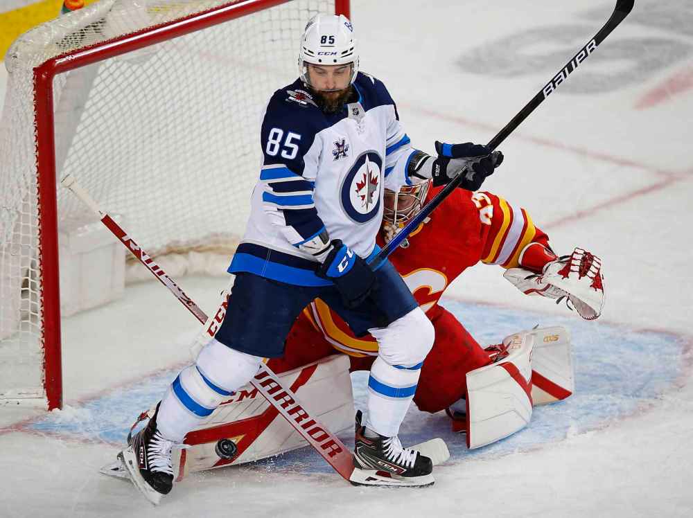 CP
Calgary Flames goalie David Rittich makes a save while Winnipeg Jets' Mathieu Perreault tries to block him from seeing the puck during the second period. (Todd Korol / The Canadian Press)