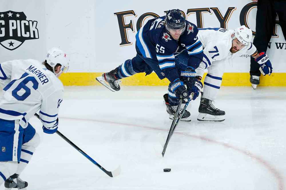 CP
Winnipeg Jets' Mark Scheifele (55) and Toronto Maple Leafs' Nick Foligno (71) fight for possession during the first period. (John Woods / The Canadian Press)