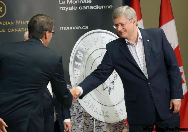 Prime Minister Stephen Harper, right, with True North Chairman Mark Chipman, unveil a commemorative 50-cent coin that pays tribute to the Winnipeg Jets. (Joe Bryksa / Winnipeg Free Press)