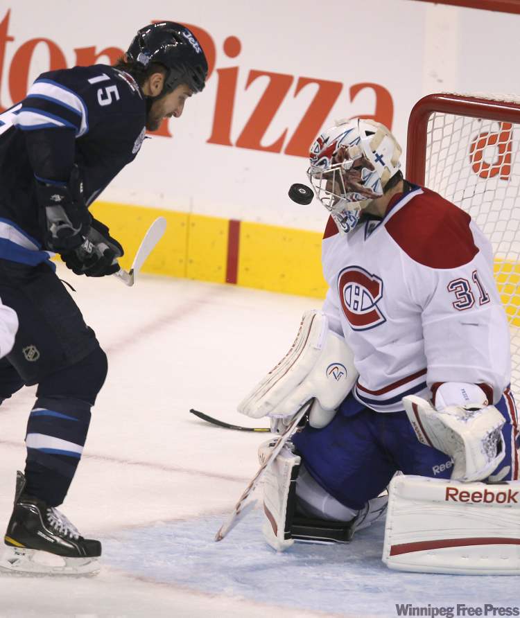 Canadians goaltender Carey Price keeps his eyes on the puck as Tanner Glass storms the net during third period (Joe Bryksa / Winnipeg Free Press)