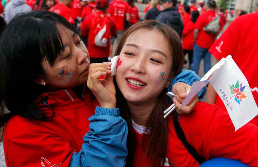 BORIS MINKEVICH / WINNIPEG FREE PRESS
Candy Tang and Wanruanru Li put on some temporary Canada Day tattoos.