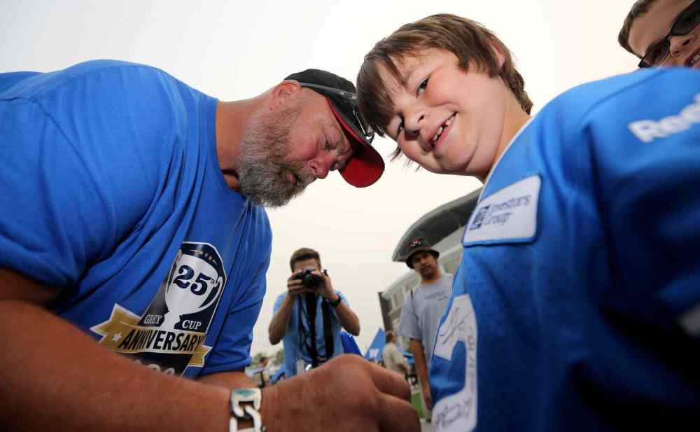 TREVOR HAGAN/WINNIPEG FREE PRESS
Bomber alumni, Chris Walby, signing an autograph for eight-year-old Nicholas Mason.