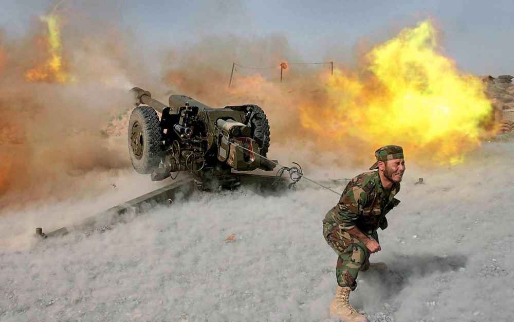 An Afghanistan National Army member grimaces as he fires a Russian-made 122-mm howitzer D-30 artillery gun during training by the Operational Mentoring and Liaison Team at a forward operating base in the Panjwayi District of Afghanistan in 2008.
