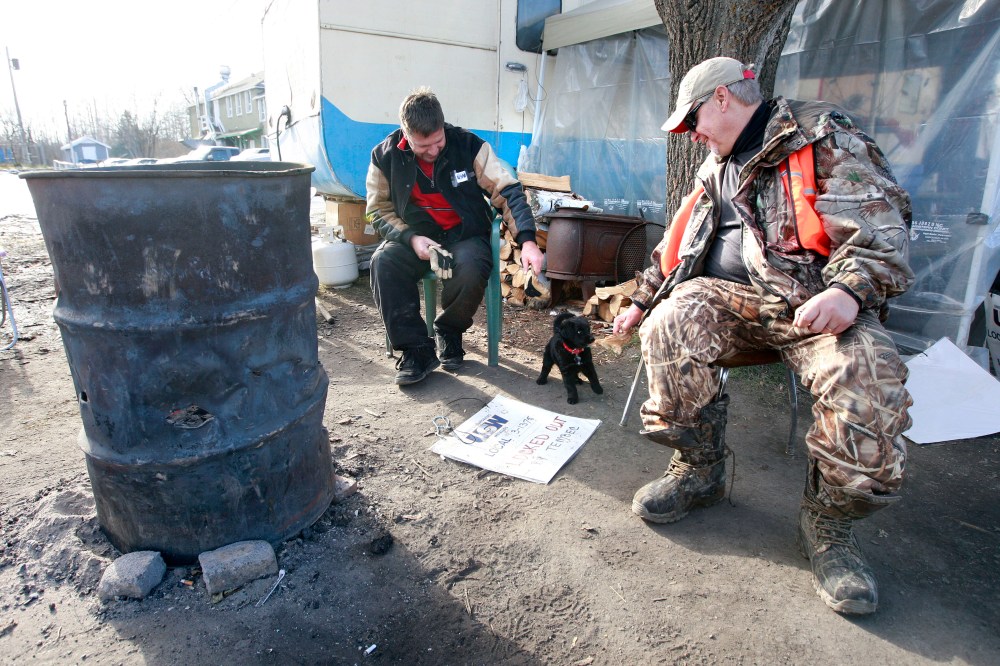 KEN GIGLIOTTI WINNIPEG FREE PRESS / Nov. 6 2009 - 091106 - Lindor Reynolds story - Pine Falls Tembec Paper mill lock out is in its second month and the strain is starting to show on the locked out workers , their families and the community business in the town . In pic Cameron Zacharis plays with Fern Vincent (right) pup at the lockout hq outside the Tembec main gate