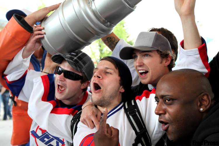 Ruth Bonneville Winnipeg Free Press
Hundreds of NHL Hockey fans scream under the canopy at The Forks to celebrate their return. Steve Kaltchev (centre with black toque) celebrates with his friends and a plastic Stanley Cup at the Forks Tuesday afternoon.