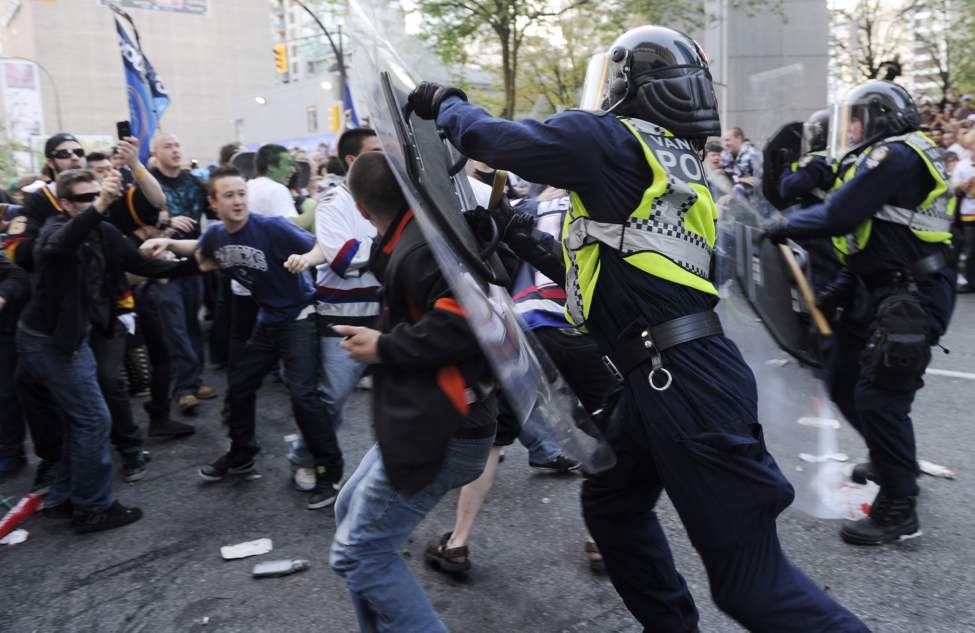 Riot officers charge into the crowd as fans riot after the Vancouver Canucks lose to the Boston Bruins in the 2011 Stanley Cup final in Vancouver, British Columbia, Canada, on Wednesday, June 15, 2011. (Gerry Kahrmann/PNG/Postmedia News/MCT)
