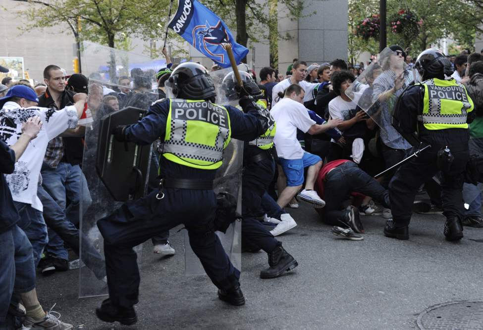 Riot officers charge into the crowd as fans riot after the Vancouver Canucks lose to the Boston Bruins in the 2011 Stanley Cup final in Vancouver, British Columbia, Canada, on Wednesday, June 15, 2011. (Gerry Kahrmann/PNG/Postmedia News/MCT)