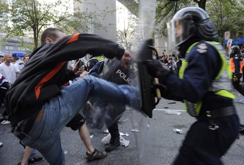 Police and rioters clash after the Vancouver Canucks lose to the Boston Bruins in the 2011 Stanley Cup final in Vancouver, British Columbia, Canada, on Wednesday, June 15, 2011. (Gerry Kahrmann/PNG/Postmedia News/MCT)