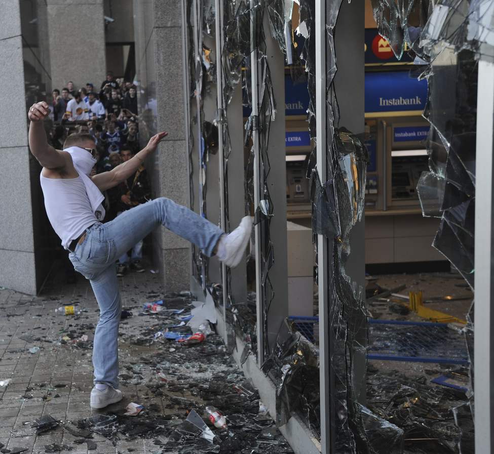 Rioters smash window on a bank on Georgia Street after game 7 of the Stanley Cup finals between the Canucks and the Boston Bruins in Vancouver, BC Wednesday, June 15, 2011. (Photo by Jason Payne/ PNG)