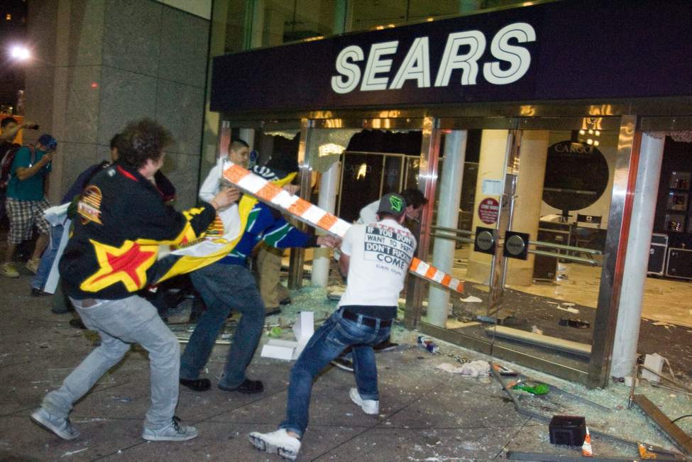 Rioters break the front doors of a Sears department store on Granville Street during the riot following game 7 of the NHL Stanley Cup final in downtown Vancouver, B.C., on Wednesday, June 15, 2011. THE CANADIAN PRESS/Geoff Howe