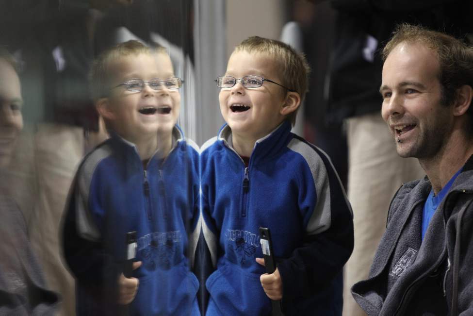 Four-year-old Alain Geal enjoys watching the players on the ice with his dad, Mike, Saturday.