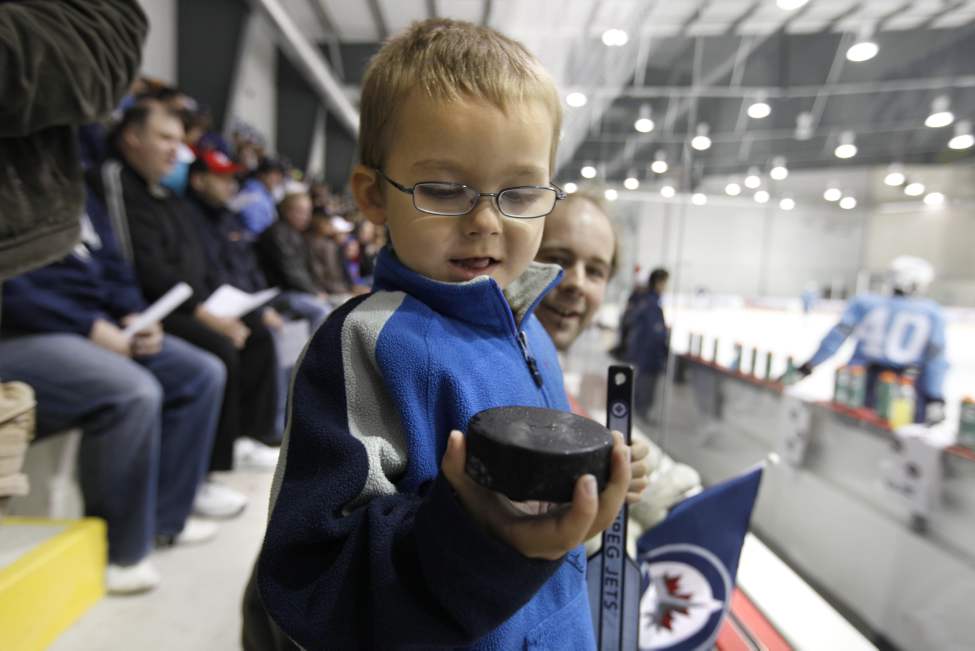 RUTH BONNEVILLE / WINNIPEG FREE PRESS
Four year old Alain Geal looks at a puck he grabbed after it flew over the glass.
