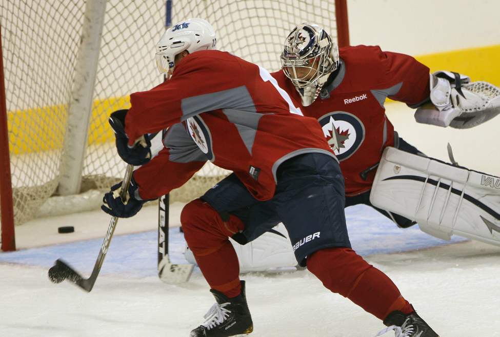 JOE BRYKSA / WINNIPEG FREE PRESS
Winnipeg Jets Kyle Welwood  takes a stab at the puck in fron of goaltender Ondrej Pavelec at practice Sunday afternoon.