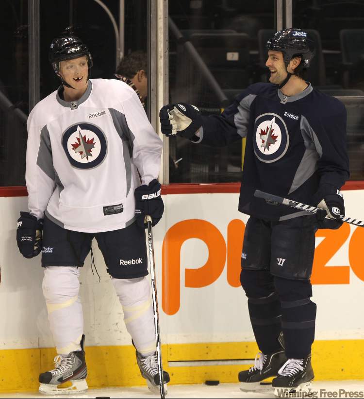 Joe Bryksa / Winnipeg Free Press
Winnipeg Jets Carl Klingberg, left, smiles as teammate Ron Hainsey welcomes him to morning practice at the MTS Center in Winnipeg Thursday. Klingberg was called up from the AHL yesterday.
