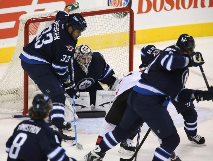TREVOR HAGAN / WINNIPEG FREE PRESS
Winnipeg Jets' goaltender Ondrej Pavelec (31) peaks through the crowd as the team hosts the Ottawa Senators' in the first game of the season at MTS Centre, Saturday.