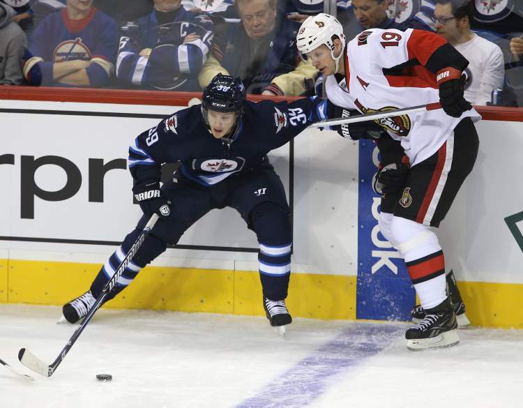 TREVOR HAGAN / WINNIPEG FREE PRESS
Winnipeg Jets' Tobias Enstrom (39) battles with Ottawa Senators' Jason Spezza (19) during the first period in the first game of the season.