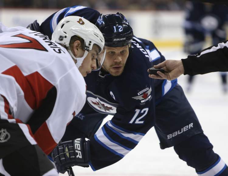 TREVOR HAGAN / WINNIPEG FREE PRESS
Winnipeg Jets' Olli Jokinen eyes the puck prior to a face-off against Ottawa Senators' Kyle Turris during the second period of play at MTS Centre Saturday.