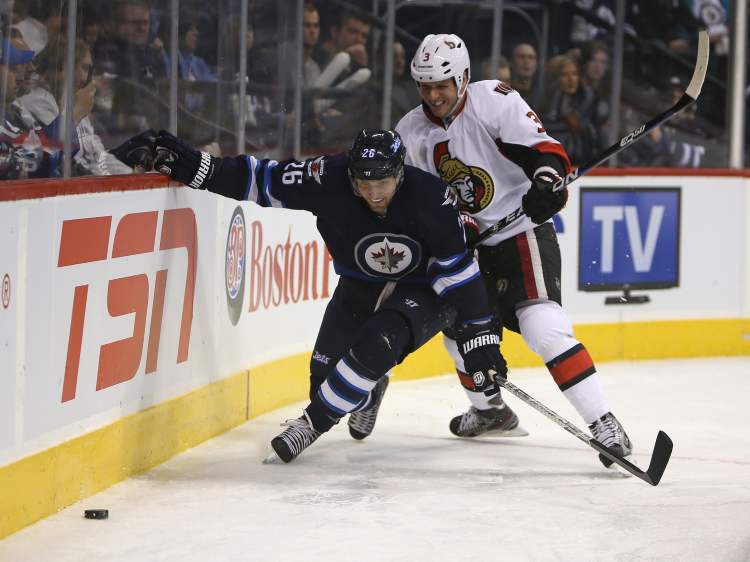TREVOR HAGAN / WINNIPEG FREE PRESS
Winnipeg Jets' Blake Wheeler fights with Ottawa Senators' Chris Phillips behind the Senators net during the second period of play at MTS Centre Saturday.