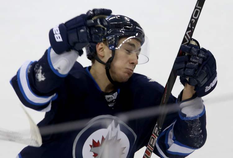 Winnipeg Jets' Alexander Burmistrov takes a stick in the face from Carolina Hurricanes' Drayson Bowman during the first period.