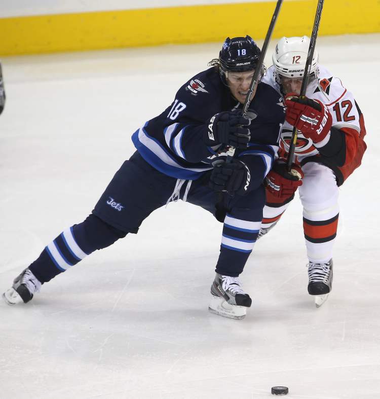 TREVOR HAGAN / WINNIPEG FREE PRESS
Winnipeg Jets' Bryan Little and Carolina Hurricanes' Eric Staal battle for the puck during the first period.