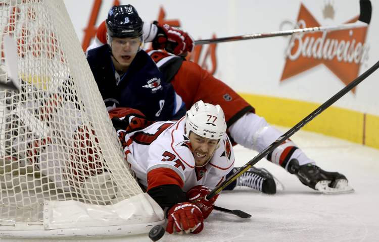 TREVOR HAGAN / WINNIPEG FREE PRESS
Winnipeg Jets' Alexander Burmistrov looks on as Carolina Hurricanes' Joe Corvo hits the puck with his hand behind the Carolina net during the second period.