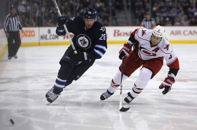 TREVOR HAGAN / WINNIPEG FREE PRESS
Winnipeg Jets' Blake Wheeler (26) and Carolina Hurricanes' Tim Gleason (6) race to the puck during second-period action.