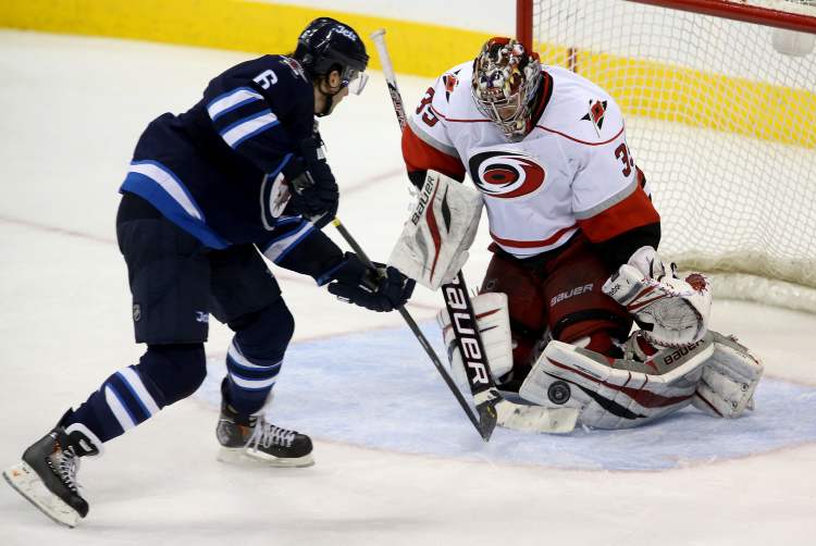 TREVOR HAGAN / WINNIPEG FREE PRESS
Winnipeg Jets defenceman Ron Hainsey (6) is stopped by Carolina Hurricanes' goaltender Justin Peters (35) during third-period action.