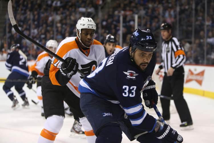 TREVOR HAGAN / WINNIPEG FREE PRESS
Winnipeg Jets' Dustin Byfuglien (33) is chased into the corner by Philadelphia Flyers' Wayne Simmonds (17) during the second period NHL hockey action, Saturday. The Jets returned from a poor first period and defeated the Flyers 4-1.
