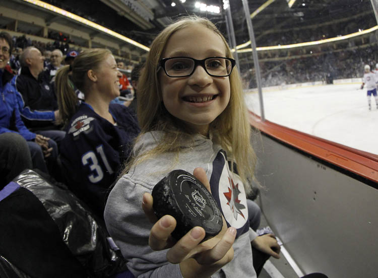TREVOR HAGAN/WINNIPEG FREE PRESS
Theresa Buchel, 10, holds the game puck she was handed by linesman during the first period of the Montreal Canadiens against Winnipeg Jets Thursday night.